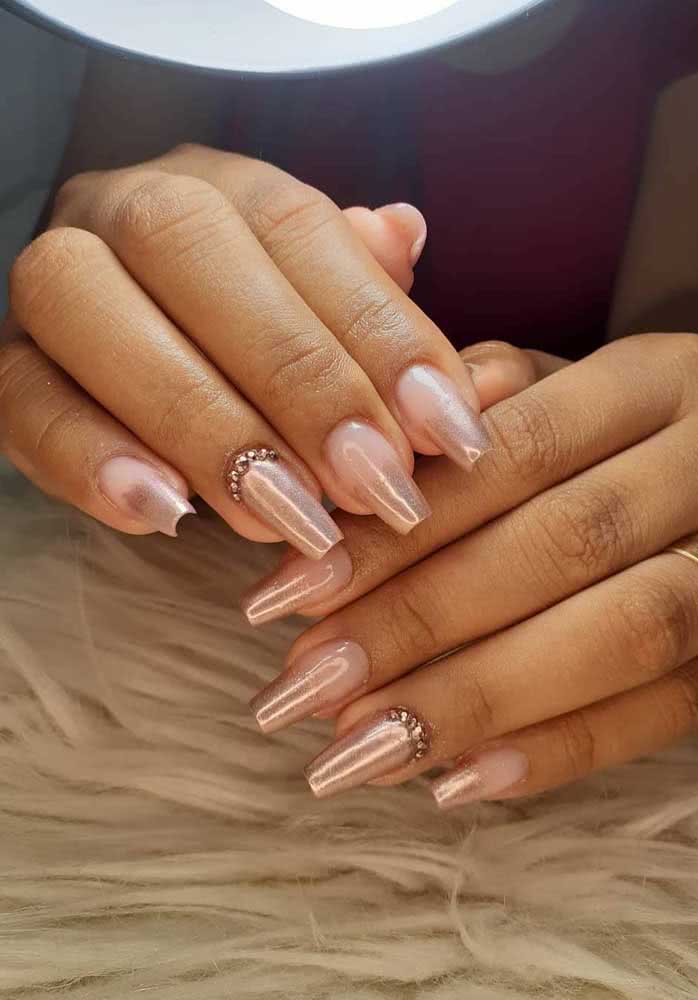 As filhas únicas ganham destaque com um contorno de strass dourado na parte interna da unha, próxima à cutícula, nesta nail art com esmalte perolado.