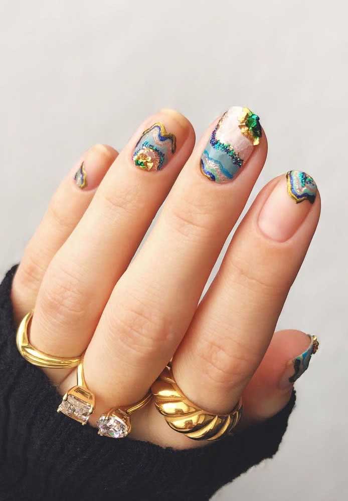 Leve a temática de pedrarias para outro nível com uma nail art cheia de camadas de cor e textura imitando as pedras no seu estado bruto.