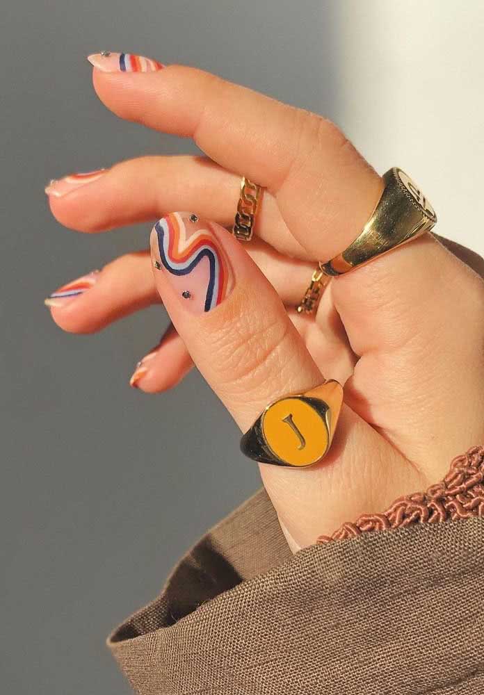 Unhas decoradas com pedras azuis e um rio super colorido para um visual descontraído e moderno.