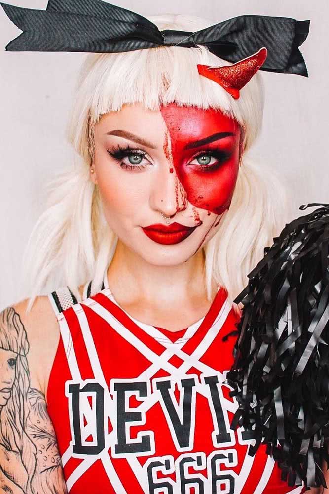 Uma animadora de torcida infernal mostrando sua real aparência nesta maquiagem de demônio vermelho com direito a chifres e tudo mais.