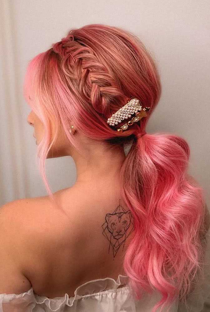 A trança espinha de peixe forma uma tiara neste visual elegante e divertido ao mesmo tempo neste rabo de cavalo rosa.