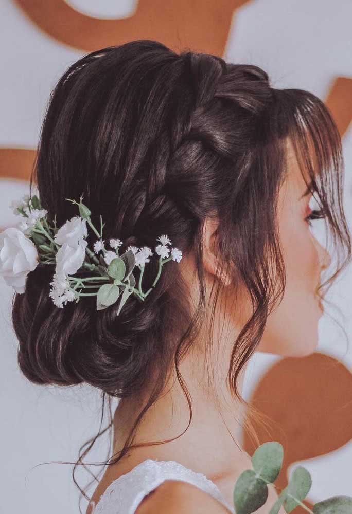 Os coques baixos soltinhos estão entre as escolhas mais populares de penteados presos para noivas e madrinhas e ficam ainda mais lindos quando são adornados com arranjos florais. 