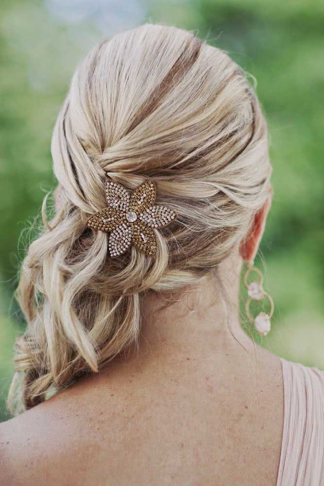 A presilha em formato de flor com pedras chama a atenção e traz mais charme para este penteado preso simples. 