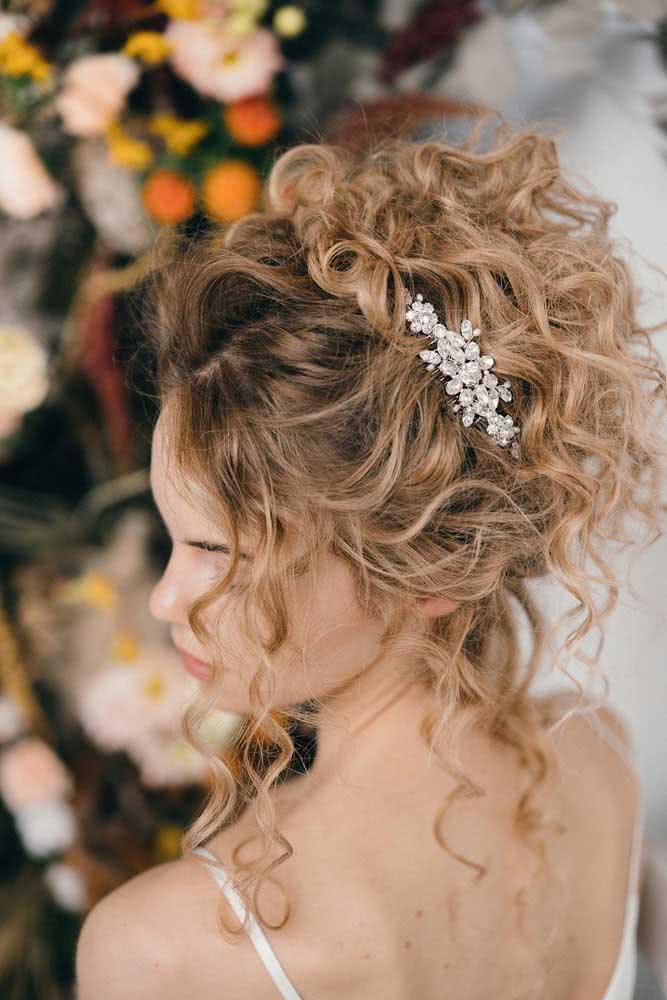 Penteado preso com cachos, que dá destaque para as mechas em ondas e forma um visual leve e sofisticado para casamentos e outros eventos sociais. 