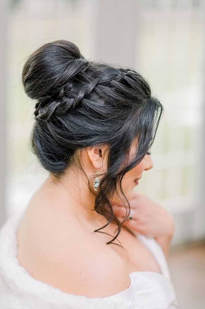 A trança holandesa fininha vai rodeando o coque alto e tira este penteado preso do lugar comum.