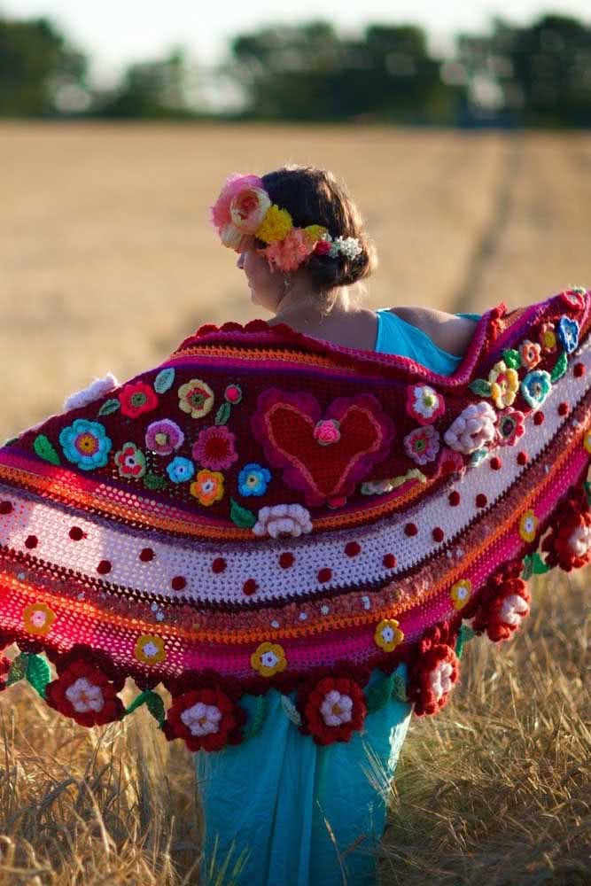 E para deixar qualquer look mais alegre e divertido, um xale de crochê com aplicação de flores tridimensionais e pompons na mesma técnica. 