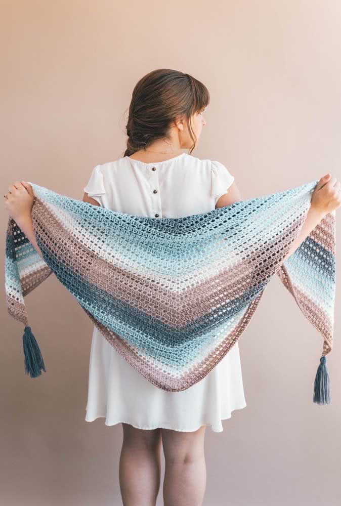 Para completar este look cozy e delicado em branco, um xale de crochê degradê azul e rosa com tassels nas pontas. 
