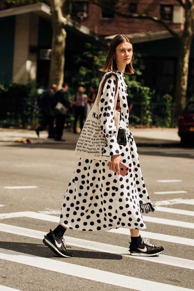 Já este look ousado P&B com vestido de estampa poá, meia alta e tênis é uma garantia de conforto e estilo para qualquer fashionista.