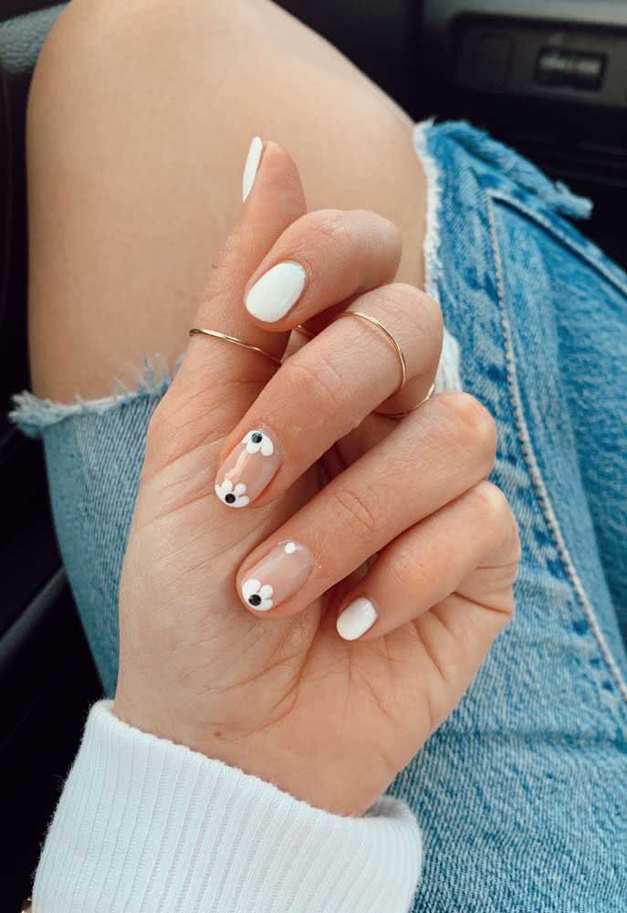 Nestas unhas decoradas simples brancas, as unhas gêmeas ganham destaque com o fundo nude e flores com pétalas brancas desenhadas nas extremidades. 