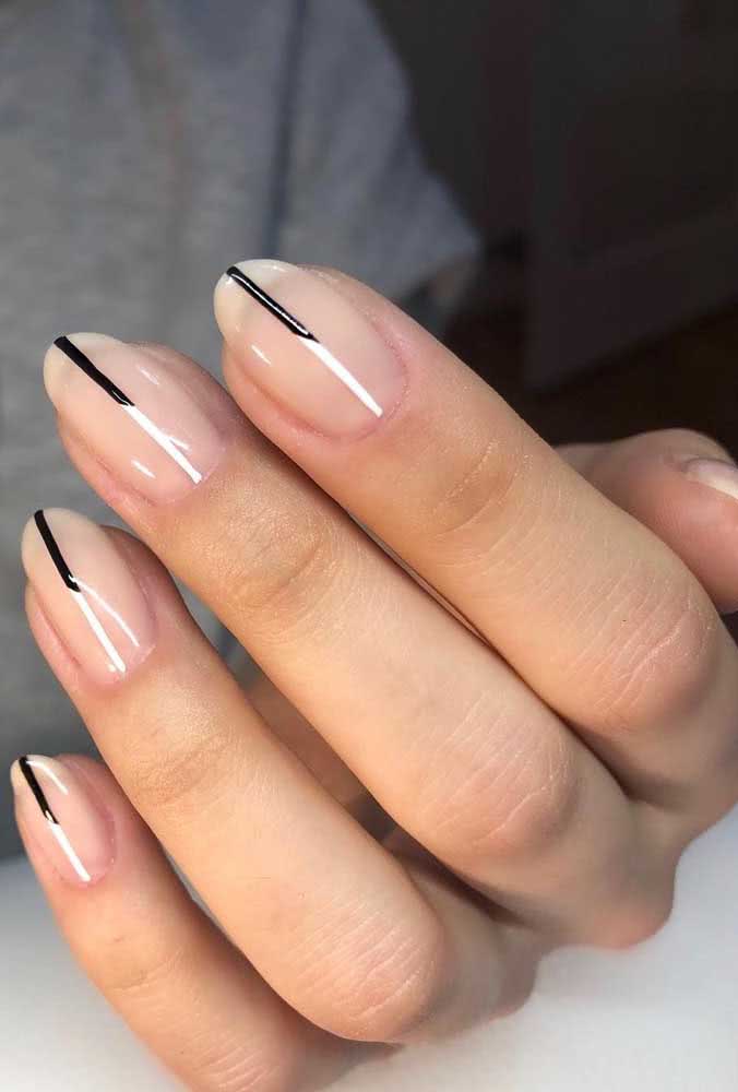 Um risco preto vai da extremidade até o centro e transforma o visual simples destas unhas.