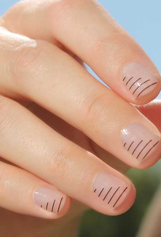 Um degradê de linhas fininhas pretas cria um visual half nail na diagonal bem discreta e que valoriza o tom natural da unha. 