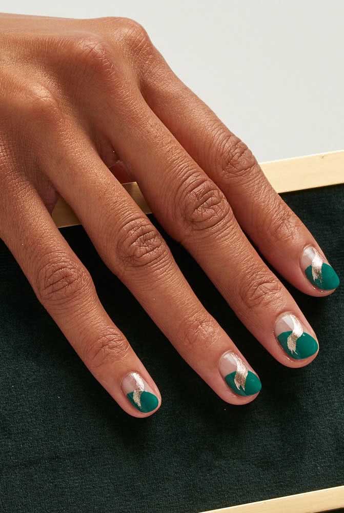 Unhas decoradas simples super elegantes em uma composição meio a meio com verde e um toque leve e delicado de dourado. 