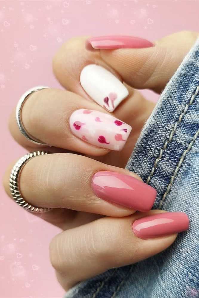 Unhas decoradas simples com espírito romântico com a composição com corações rosas nas unhas gêmeas. 