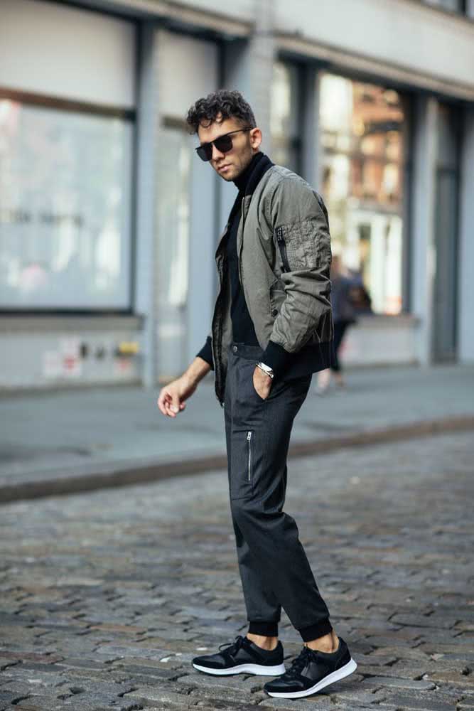 Num estilo urbano e com muita personalidade, calça jogger com blusa preta de gola alta e jaqueta.