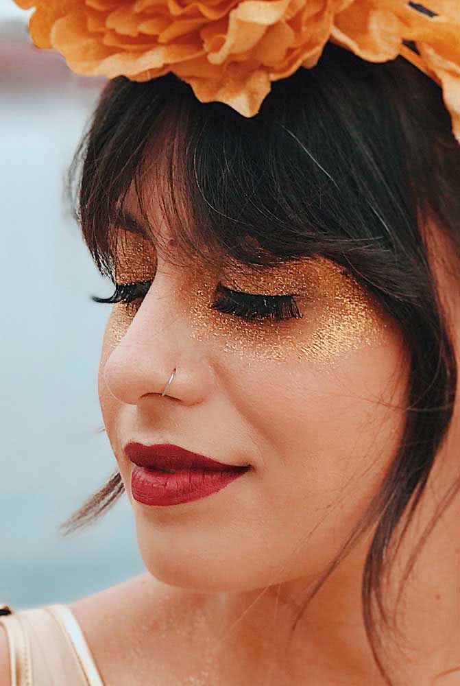 Já para curtir o carnaval com muito estilo e alegria, vale uma make com batom vermelho e muito (muito!) glitter dourado nos olhos.