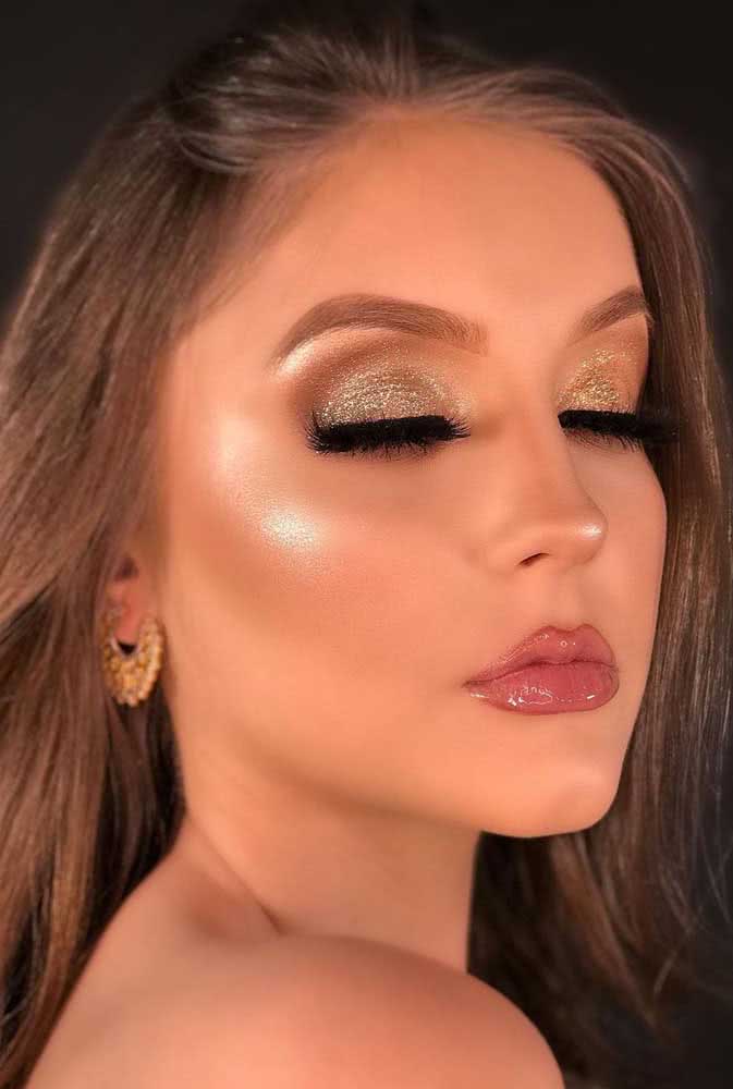 Cílios bem demarcados com máscara preta e sombra glitter dourada para arrasar no look de festa.