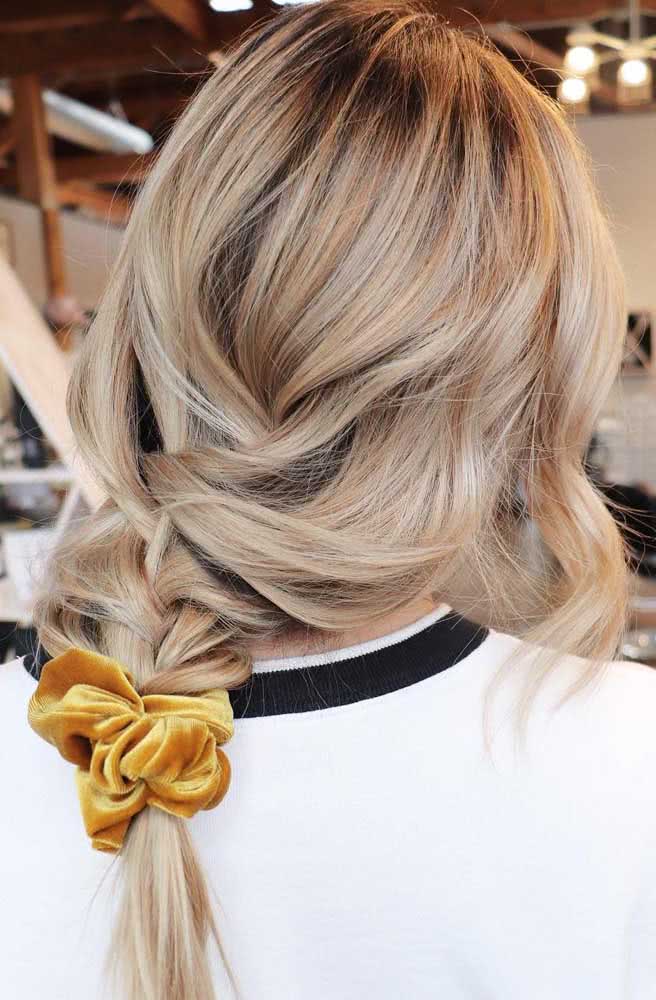 Quer adotar um visual messy com um penteado fácil de fazer sozinha? Então aposte em uma trança tradicional bem soltinha e presa com um elástico frufru colorido.