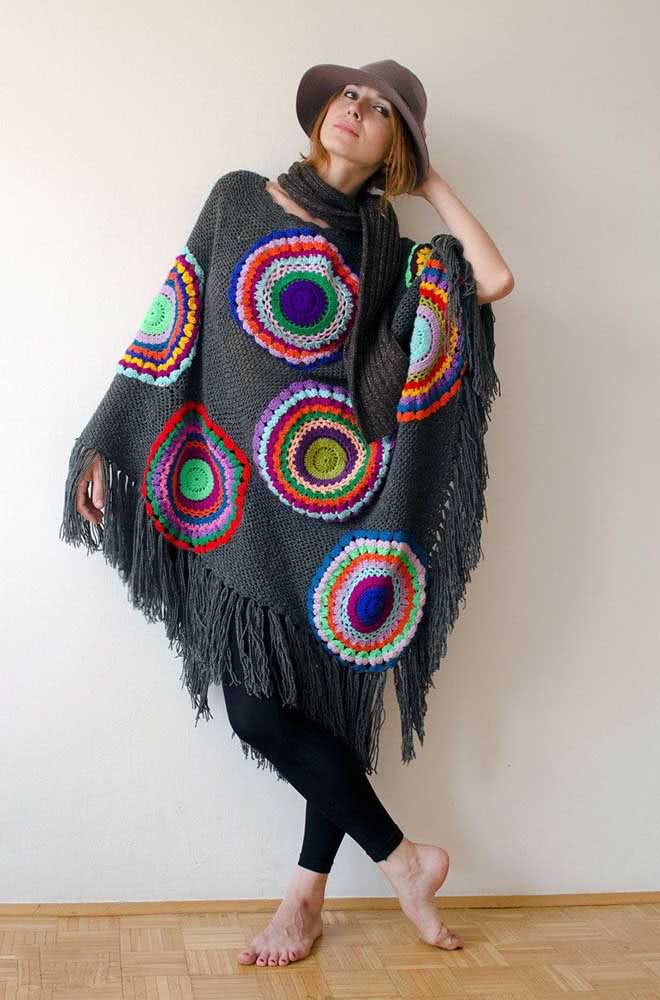 Mas se você está buscando uma ideia de poncho de crochê que sai do lugar comum, dá uma olhada nesta ideia com mandalas coloridas aplicadas sobre a trama cinza! 