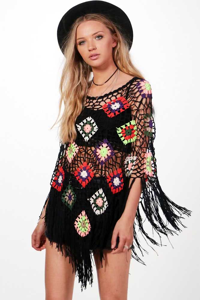 Este poncho de crochê preto com pontos vazados e squares florais rouba todas as atenções deste look perfeito para curtir um festival em dia ensolarado.