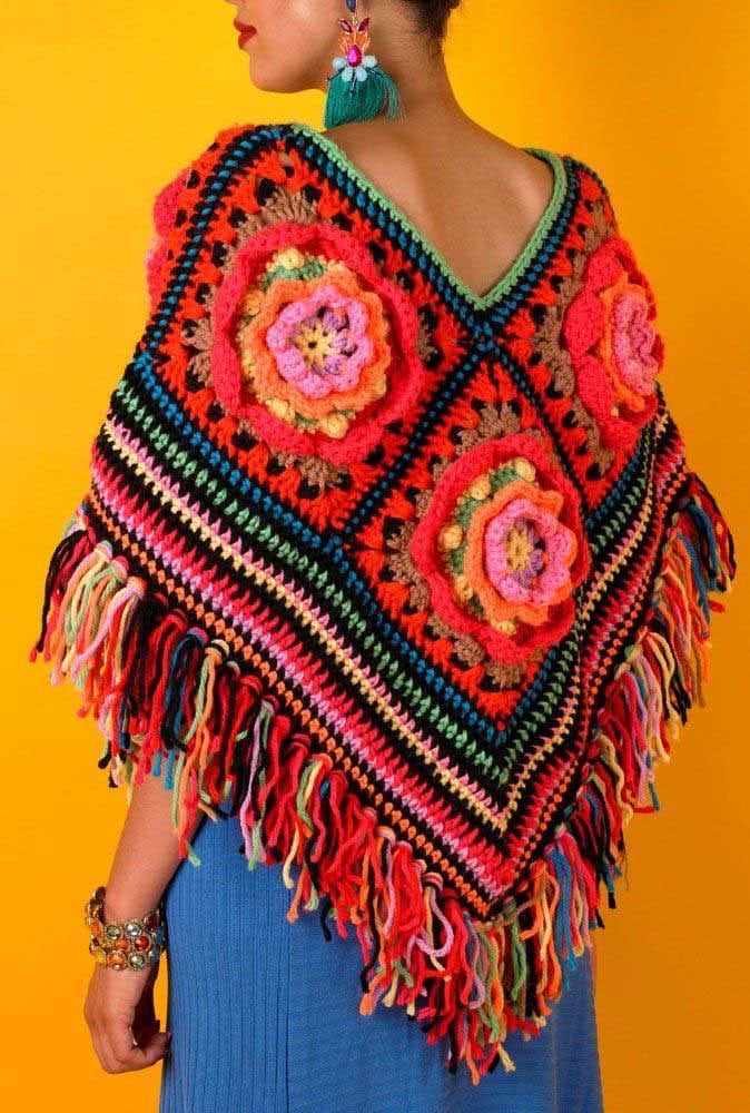 Outra ideia de poncho de crochê feito com squares, desta vez com flores tridimensionais e franjas multicoloridas. 