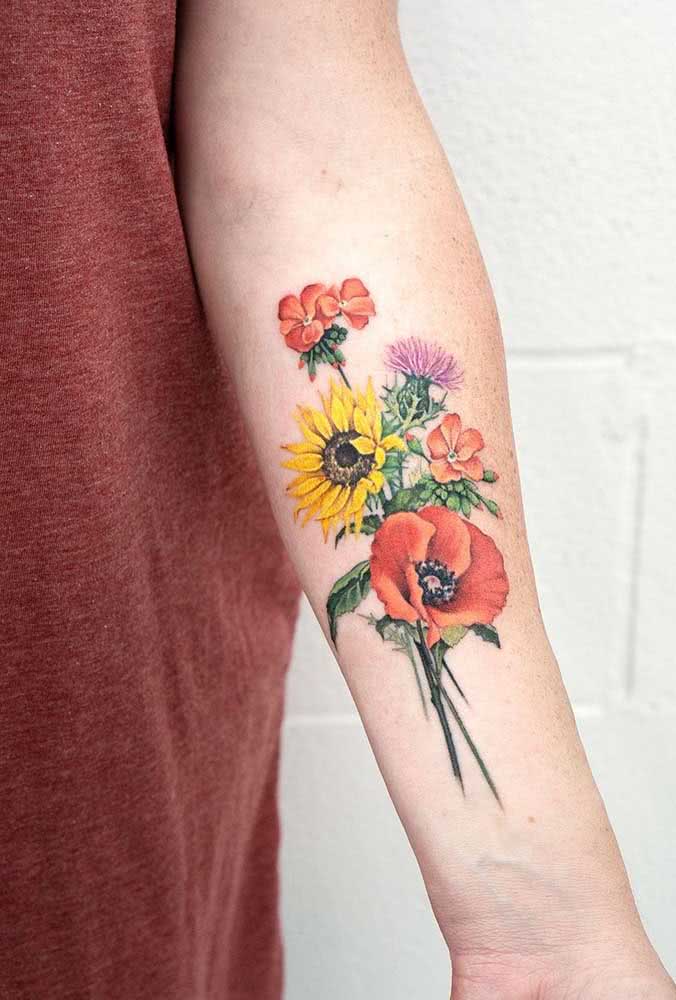 Um buquê de flores com muita cor e detalhes é a ideia perfeita para uma tatuagem feminina em micro realismo.