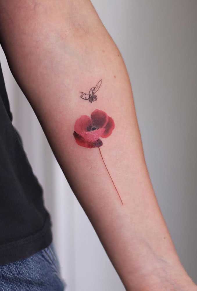 Dá uma olhada na mistura de técnicas desta tatuagem de flor com joaninha. 