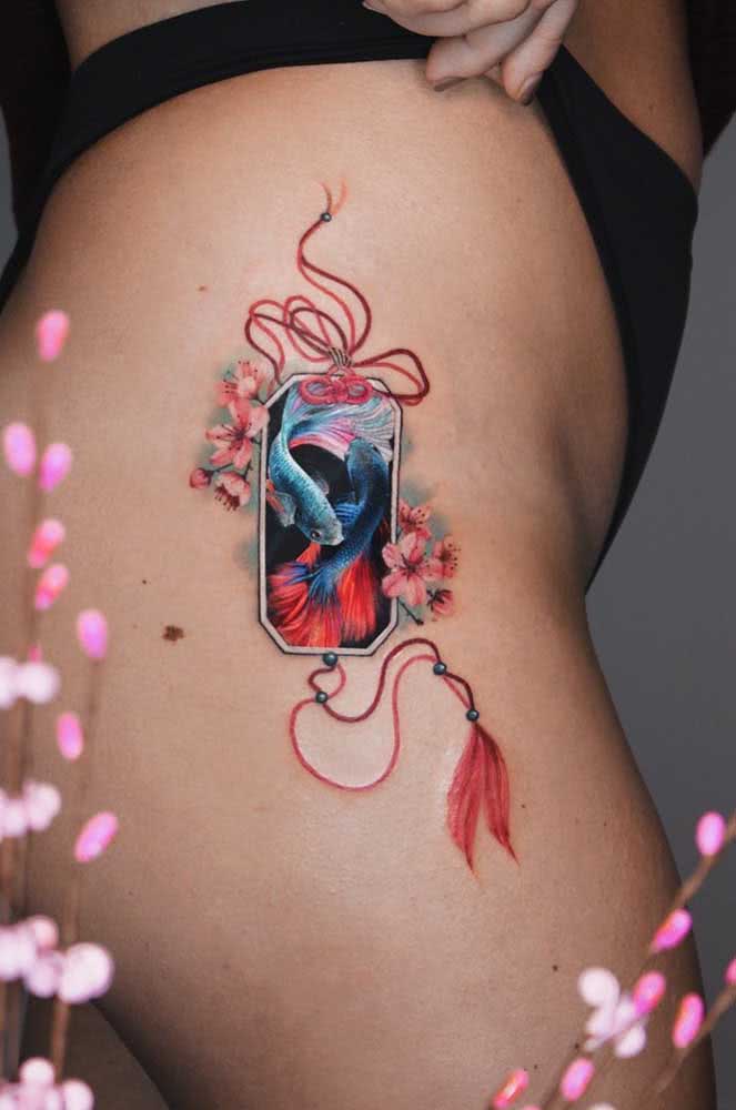 Inspiração oriental neste desenho de carpas com flores de cerejeira cheio de detalhes e cores vibrantes no quadril. 
