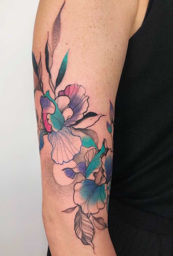 Mistura de técnicas nesta tatuagem que rodeia todo o braço com flores e folhas. 