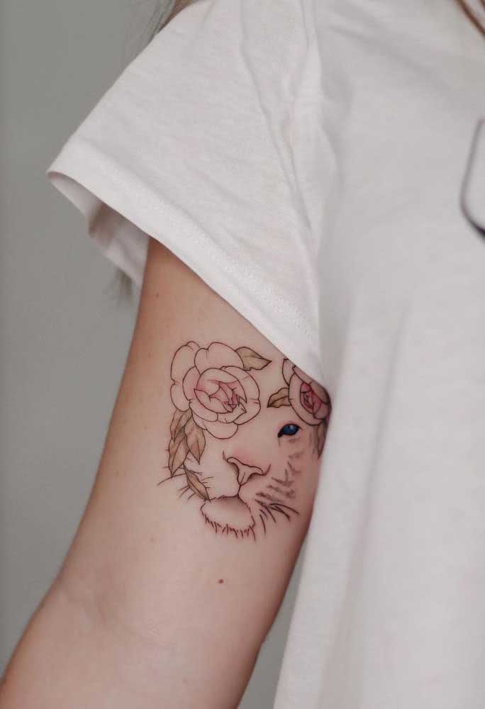 Cheia de delicadeza e adornada com rosas, uma tatuagem de leão feminina.
