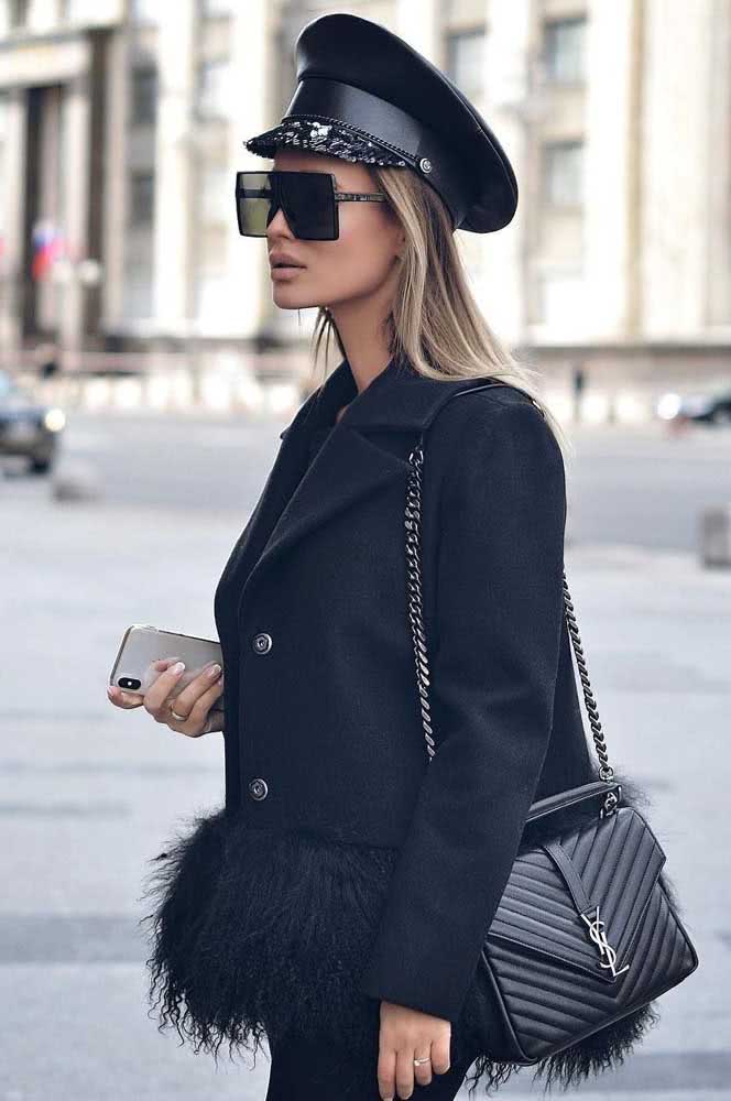 Um pouco mais de glamour e diversão que quebra a formalidade deste casaco preto de alfaiataria com uma barra macia e cheia de pelinhos.