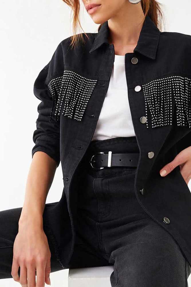 Franjinhas metalizadas aplicadas à parte da frente da jaqueta jeans preta finalizam um estilo glamouroso e cheio de atitude. 