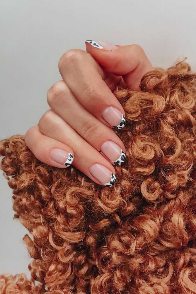 Um estilo que nunca sai de moda é a unhas decorada com francesinha. Mas, em 2021, a tendência é adicionar padrões e mais cores nela, como este animal print de vaquinha.