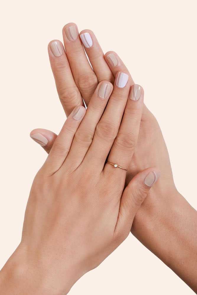 Se você gosta de composições com esmaltes clarinhos, dá uma olhada nesta half nail vertical em branco e nude. 