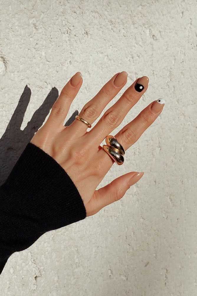 Perfeito para quem busca um estilo mais clássico, mas cheio de personalidade. Unhas decoradas nude com detalhe yin-yang para trazer equilíbrio para o seu visual.