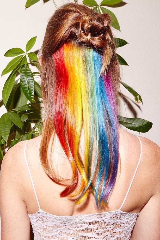 Um arco-íris nas mechas inferiores do cabelo, que fica totalmente à mostra só com um penteado meio preso.