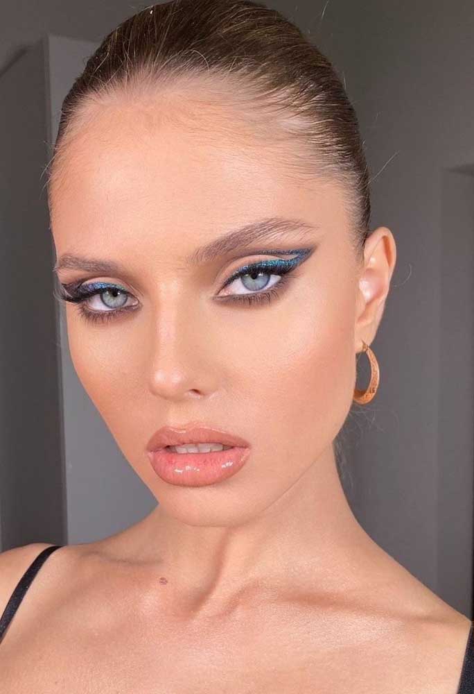 Um olhar gatinho com este cut crease feito com delineador azul glitter e um toque de sombra preta esfumada na pálpebra inferior.