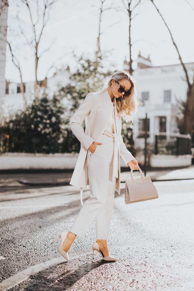 Mais uma ideia de look com roupa social feminina toda branca, dessa vez com blazer alongado.