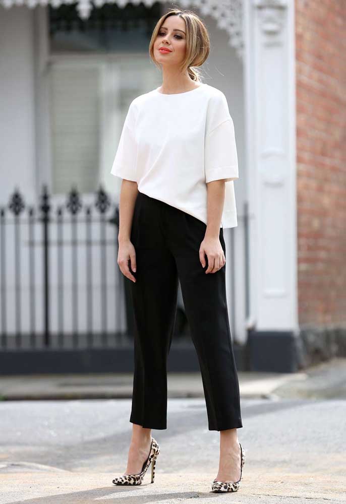 Prefere as roupas mais soltinhas? Confira esta ideia de look simples e cheio de estilo com calça preta, blusa branca e sapato com estampa de oncinha.