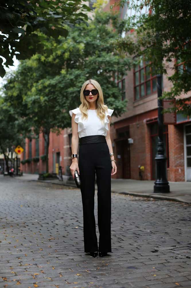 A cintura alta da calça social e o uso do salto alonga a silhueta deste exemplo de look com roupa social feminina em preto e branco.