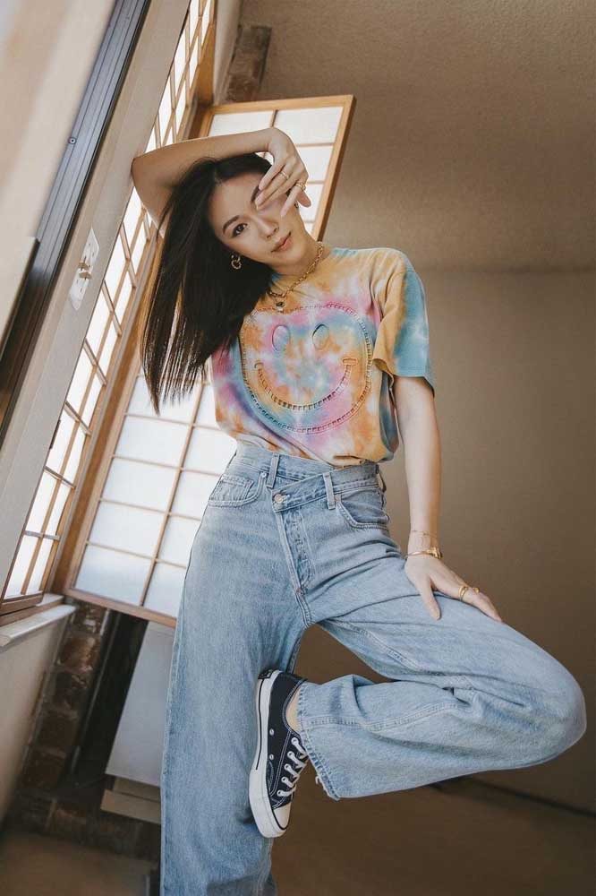 Mais camiseta tie dye, dessa vez numa combinação com calça jeans pantalona e all star preto clássico, num look super anos 1990.