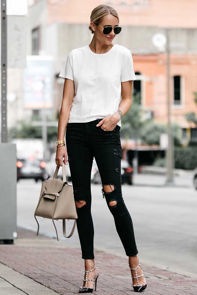 Os rebites no sapato de salto e o visual destroyed da calça jeans deixam esse look com camiseta básica branca cheio de atitude.