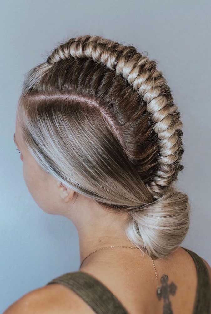 Mas se você está em busca de um penteado ousado e diferente para arrasar, confira essa ideia com trança embutida bem cheia no topo da cabeça, como um moicano, que se encontra com os fios laterais em um coque baixo. 