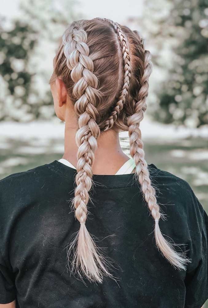 A trança embutida boxeadora ganha um detalhe a mais neste exemplo: uma trança mais fina contorna a linha que divide o cabelo ao meio. 