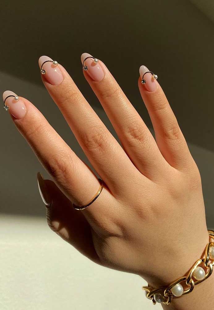 O semi círculo com jóias nas pontas trazem mais ousadia para a decoração destas unhas clarinhas.