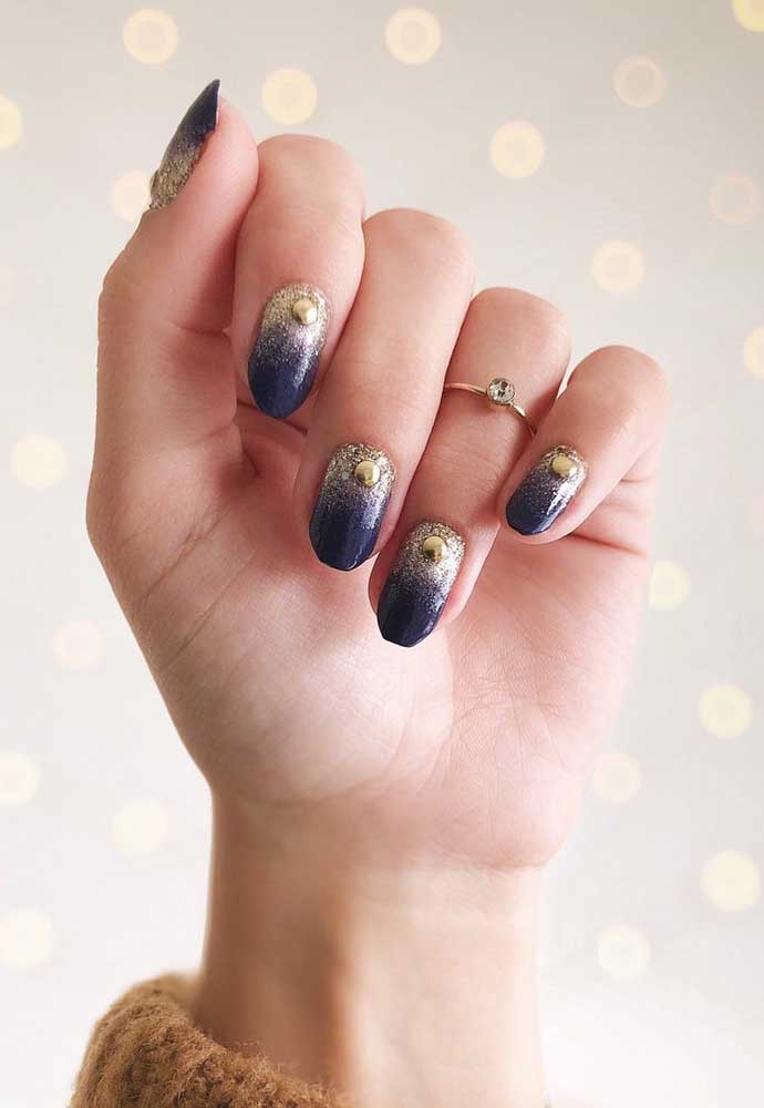 E se você gosta de um visual místico, dá uma olhada neste degradê de glitter dourado com jóia sobre o esmalte azul marinho. 