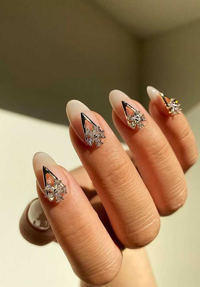 Com as unhas esmaltadas somente com base, a jóia em forma de seta e flor fica a cargo da decoração nesta nail art.