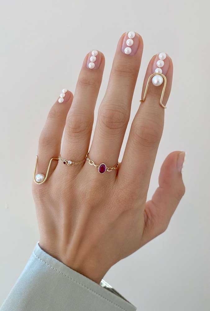 Num visual minimalista e sofisticado, a escolha dos anéis com pérolas combinam com a decoração das unhas. 