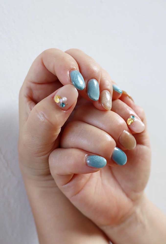 Concha, pérola e outra pedra azul: o conjunto de jóias perfeitas para compor uma nail art inspirada no oceano.