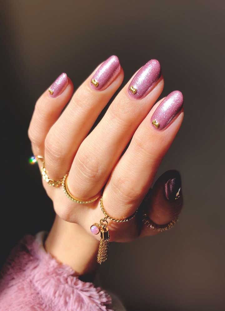 Por último, este visual com esmalte rosa cheio de glitter fica ainda mais glam com a aplicação de jóias em formato de laço. 