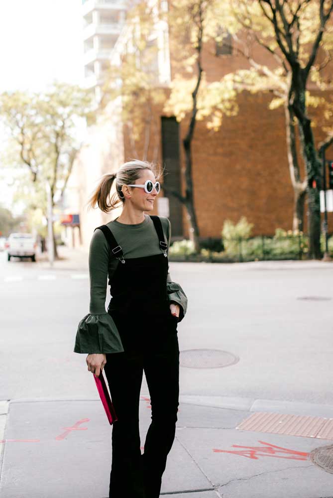 A barra volumosa da blusa verde oliva deixa esse look com macacão mais divertido.